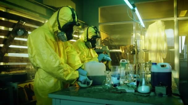 Fully Armed Special Anti-Narcotics Task Forces Soldier Arrests Two Clandestine Chemists Working in the Drug Producing Underground Laboratory. Chemists Raise Hands and Surrender. A lot of Functional Drug Production Equipment is Standing Around. — Stock Video