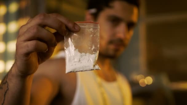 Brutal Drug Dealer Wearing Sleeveless Shirt and Gold Chain Holds and Offers Sample Bag Full of Drugs. He Lives in the Abandoned Building with Boarded Up Windows. — Stock Video