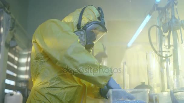 In the Underground Laboratory Two Clandestine Chemists Wearing Protective Masks and Coveralls Pack Bags of Synthesised Crystal Meth into Boxes for Further Distribution. Laboratory is Full of Illegal Equipment. They Squat in an Abandoned Building. — Stock Video