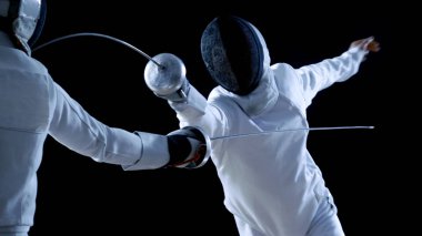 Two Professional Fencers Show Masterful Swordsmanship in their Foil Fight. They Attack, Defend, Leap and Thrust and Lunge. Shot Isolated on Black Background. clipart