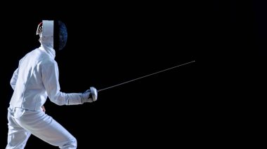 Tam donanımlı bir yetenekli Fencer eğitim onun saldırı ve hamle yan görünüm bir folyo ile. Siyah arka plan üzerine izole atış.