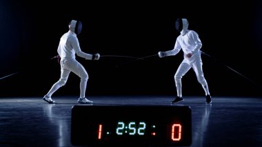 On the Championship Two Professional Fully Equipped Fencers Fight with Foils while Scoreboard Keeps the Scores of Hits. Shot on Isolated Black Background. clipart