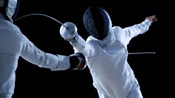 2 전문 Fencers 표시 대작 검 술 그들의 포 일 싸움에. 그들은 공격, 방어, 도약 및 추력과 돌출. 총 검은 배경에 고립. — 스톡 사진