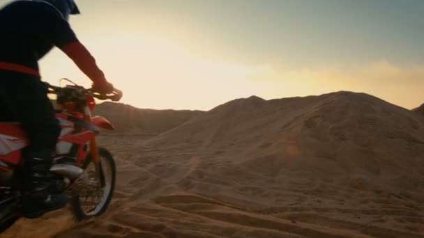 Motocross motociclista profissional dirigindo sobre a duna e mais para baixo da trilha off-road. É por do sol e faixa é coberta com fumaça / névoa . — Vídeo de Stock