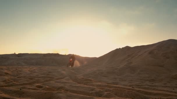 Professionell motocrossförare motorcykel körning över Dune och längre ner i Off-Road spår. Det är solnedgång och spår är täckt med rök / dimma. — Stockvideo