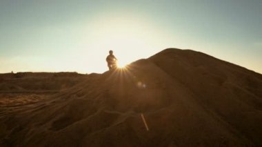 Profesyonel Motocross Fmx motosiklet binici doğal batışı manzarası için kumul ve orada durur sürücüleri.