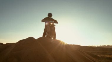 Profesyonel Motocross Fmx motosiklet binici kumul ve bakan Off-Road parça üzerinde duruyor, sonra aşağı sürücüler.