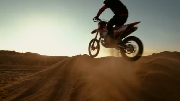Motocyklový jezdec profesionální Motocross skoky přes duny a níž Off-Road trati. Je západ slunce a stopa je pokryta kouř / mlhu. — Stock video