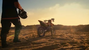 Onun kask koymak ve onun Fmx kir binmek hazırlanıyor bisiklet üzerinde taş ocağı profesyonel Motocross sürücü düşük açılı çekim kum arazi.