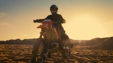 Düşük açılı Off-Road parça yolu üzerinde duran profesyonel motokros motosiklet binici bir kadeh. O gün batımı ve parça dumanla kaplı / sis.