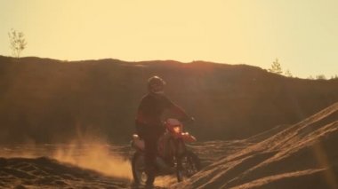 Düşük açılı Off-Road parça yolu üzerinde duran profesyonel motokros motosiklet binici bir kadeh. Günbatımı mı.