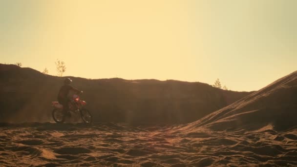 Professionele motorcross motorfiets Rider stations Over het duin en verdere beneden de Off-Road Track. Het is de zonsondergang. — Stockvideo