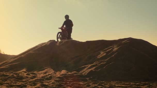 Longue vue du motocross professionnel qui roule au-dessus de la dune et plus loin sur la piste hors route . — Video