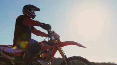 Düşük açı görüntüleri profesyonel Motocross binici Fmx motosiklet üzerinde taş ocağı ve aşırı Off-Road arazi bakan ortasında yolculuk bugün o duruyor.