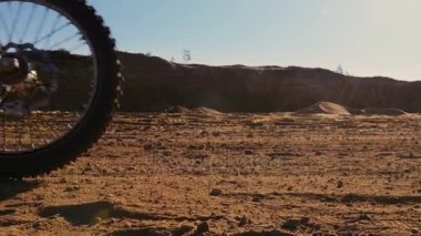 Fmx Dirt Bike kamera geçmiş kum pistte sürüş iplik tekerlekleri görüntülerini düşük açılı.