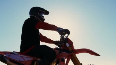 Düşük açı görüntüleri profesyonel Motocross binici Fmx motosiklet üzerinde taş ocağı ve aşırı Off-Road arazi bakan ortasında yolculuk bugün o duruyor.