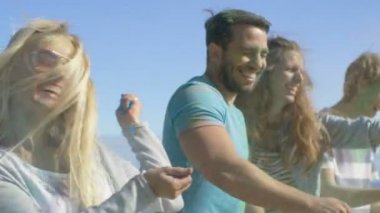Çok etnik grup genç insanlar atmak renkli toz birbirimize Holi Festivali kutlama. Büyük açık bu günde deniz kenarında eğleniyorlar.
