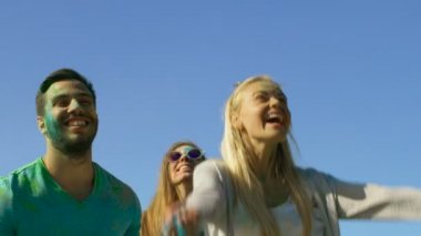 Genç çok etnik gruptan oluşan çeşitli grup düşük açılı çekim atlama ve atmak renkli toz Holi Festivali kutlamaları havada insanlar. Bu güneşli günde büyük eğleniyorlar.