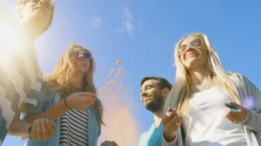 Düşük açılı atış çok etnik grup çeşitli genç insan dans ve renkli toz Holi Festivali kutlamaları Hava atma. Bu güneşli günde büyük eğleniyorlar.