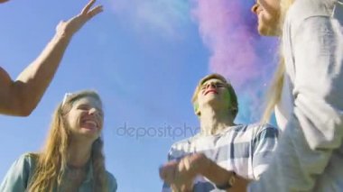 Düşük açılı bir çok etnik grup dans ve renkli toz havada atma ve Holi Festivali kutlamaları elinde yükselterek çeşitli gençlerin kadeh. Bu güneşli günde büyük eğleniyorlar.