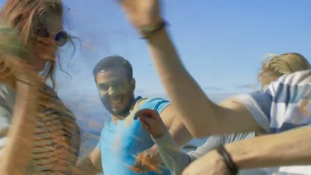 Multi-Ethnic Group of Young People Throw Colorful Powder at Each other in Celebration of Holi Festival. They Have Enormous Fun on this Clear Day by the Sea. — Stock Video