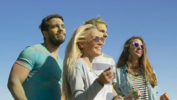 Multiethnische Gruppe verschiedener junger Leute, die zur Feier des Holi-Festes tanzen. Sie haben enormen Spaß an diesem sonnigen Tag. — Stockvideo