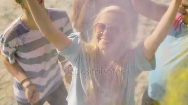 Висока кут пострілу блондинка дівчина кидали барвисті порошок в натовпі серед індуїстський фестиваль холі урочистостей. Вони мають величезне задоволення на цьому сонячний день. — стокове відео