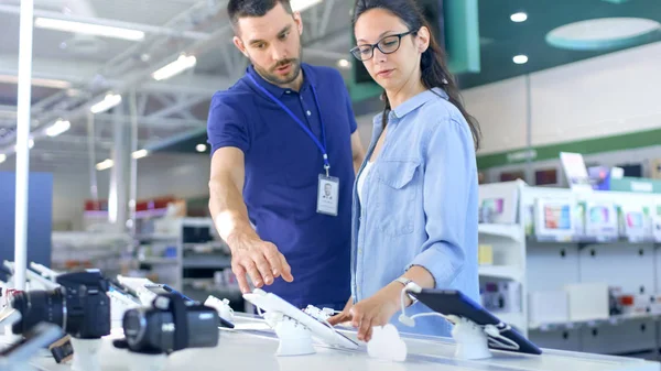 V obchodě s elektronikou konzultant poskytuje profesionální poradenství pro — Stock fotografie