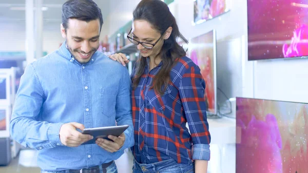 Young Beautiful Couple In the Electronics Store Looks at Latest