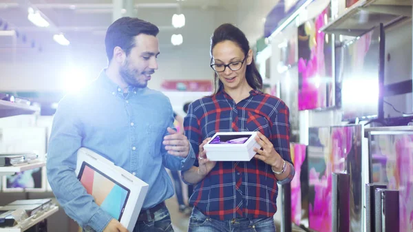 Pareja feliz caminando en la tienda de electrónica, que han comprado — Foto de Stock