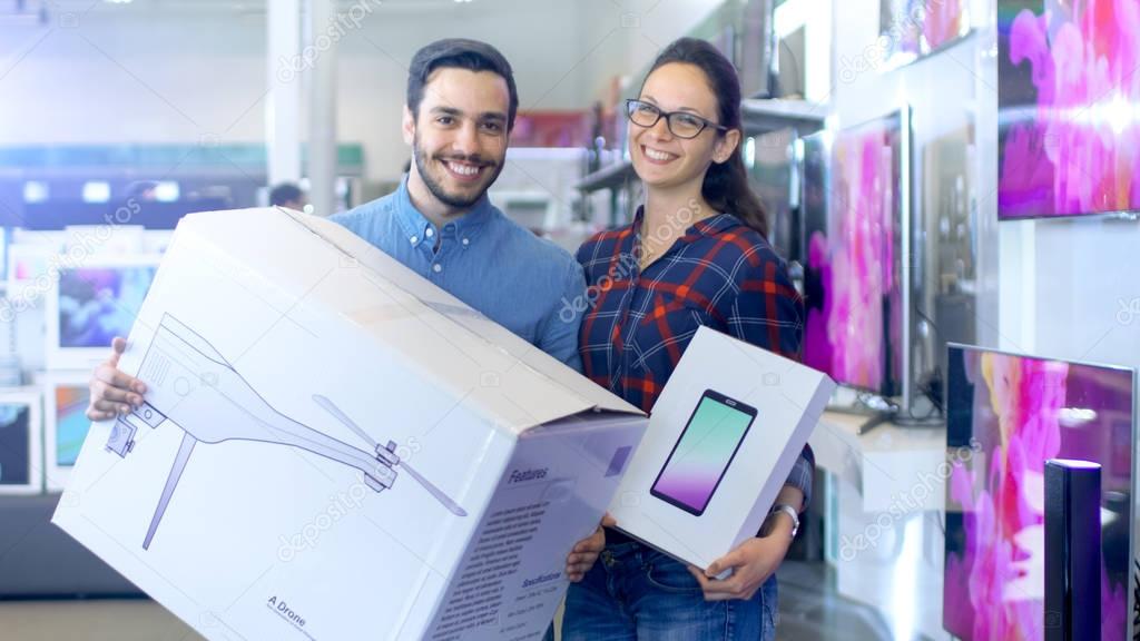 In the Electronics Store Happy Young Couple Poses with Newly Pur