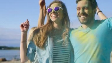 Mutlu bir çift portre renkli toz Holi Festival dans kaplı. İnsanlar içinde belgili tanımlık geçmiş eğlenceli atmak Holi toz var.
