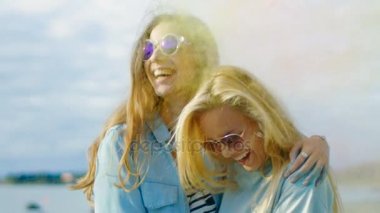 İki güzel mutlu kız gülmek ve Holi Festival kutlamak renkli toz uçan arkasında onlar konum sırt süre. Onlar hayatlarını zamanınız.