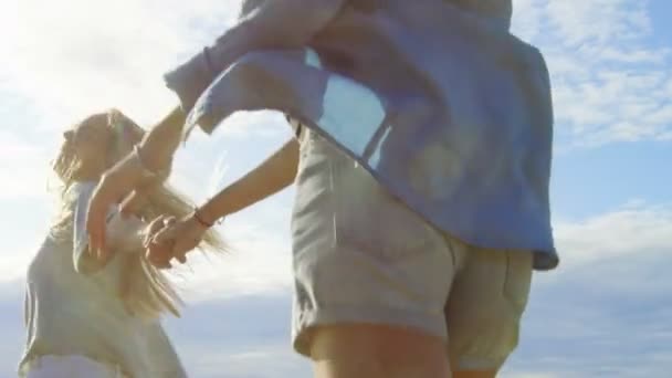 Två vackra flickor hålla händer och kör in den molnfri lycklig framtiden. Klar himmel i bakgrunden. — Stockvideo