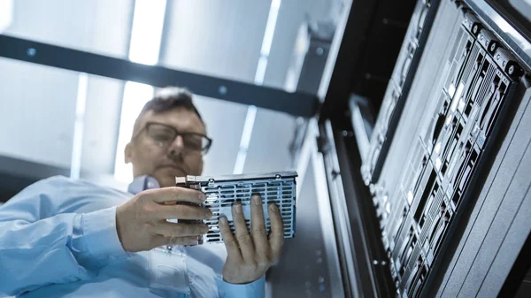 Disparo de ángulo bajo en el centro de datos de trabajo completo Ingeniero de TI instala el disco duro en el rack del servidor. Filmación detallada y técnicamente precisa . — Foto de Stock