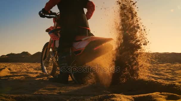Back View Footage of the Professional Rider on the FMX Dirt Bike Twisting Full Throttle Handle and Digging into the Sand with His Back Wheel. — Stock Video