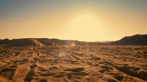 Après le tournage de la moto motocross professionnelle conduite sur la piste hors route de la saleté au milieu de la carrière panoramique tandis que le soleil se couche . — Video