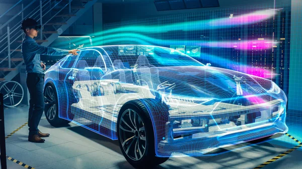 Ingegnere che indossa auricolare Realtà Aumentata Lavorando sulla nuova piattaforma di telaio per auto elettriche. Visualizzazione grafica 3D Il modello virtuale di un veicolo viene testato in galleria del vento digitale . — Foto Stock