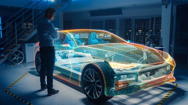 Em Automotive Innovation Facility Automobile Design Engineer Trabalhando em 3D modelo holográfico projeção de carro elétrico. Conceito Futurista de Uso de Realidade Virtual e Aumentada . — Fotografia de Stock