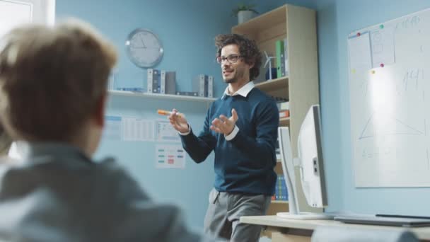 Profesor Explica la lección a la sala de clases llena de niños, dirige la lección interactiva con preguntas interesantes. En Elemental School with Group of Smart Kids Learning Science Independent Creative Thinking. — Vídeos de Stock