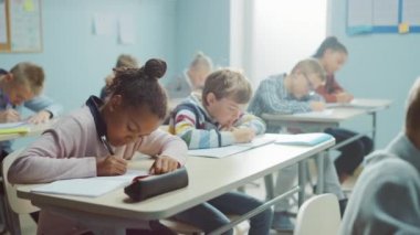 Çeşitli Parlak Çocuklar İlköğretim Sınıfı Öğretmenlerinin Ders Vermesini Dinlerken Komik Bir Şey Söyledikten Sonra Birlikte Gülün. İlkokuldaki Mutlu Genç Çocuklar Egzersiz Defterleri Yazıyor