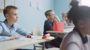Parlak Çocuklar İlköğretim Sınıfı Öğretmenlerinin Ders Vermesini Dikkatle Dinliyor. Zeki çocuklar okulda öğreniyor, egzersiz kitapları yazıyor, sınavlara giriyorlar. Hareket eden Kamera