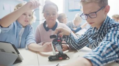 İlköğretim Okulu Robot Sınıfı: Çeşitli Çocuklar Robot Yapıyor ve Programlıyor, Konuşuyor ve Bir Takım Olarak Çalışıyor. Yazılım Öğrenen Çocuklar Tasarım ve Yaratıcı Robot Mühendisliği