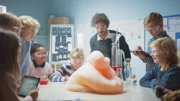 小学化学课室：热心的教师老师，通过在海狸中混入化学品，使他们发射泡沫（大象牙膏），向学生们展示科学的反应实验) — 图库视频影像
