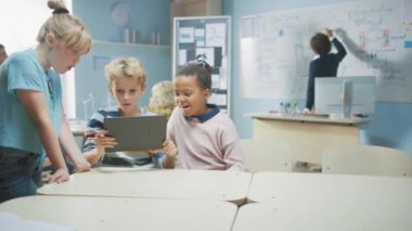 İlköğretim Okulu Bilgisayar Bilimi Sınıfı: İki Kız ve Erkek Artırılmış Gerçeklik Yazılımı ile Dijital Tablet Bilgisayar Kullanıyor, Heyecanlanıyorlar, Meraklanıyorlar, Meraklanıyorlar. STEM 'deki Çocuklar, Oynamak, Öğrenmek