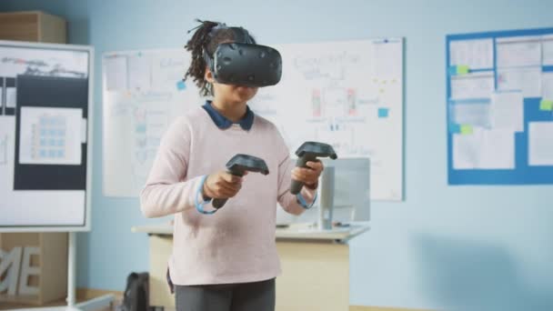 Escola Primária de Ciência da Computação: Garota Bonita Usa Auricular de Realidade Aumentada e Utiliza Controladores Aprende Lições em Realidade Virtual Emocionada, Curiosa e Interessada em Conhecimento — Vídeo de Stock