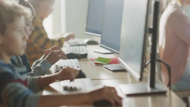 Basisschool Computer Science Classroom: Smart Little Schoolkinderen werken aan Personal Computers, leren programmeren Taal voor Software Codering. Schoolkinderen krijgen modern onderwijs — Stockvideo