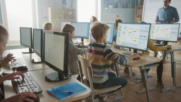 Grundskola Science Classroom: Lärare utbildar smarta små skolbarn som arbetar med persondatorer, lär sig programmeringsspråk för programvaruboende.Skolbarn får modern utbildning — Stockvideo