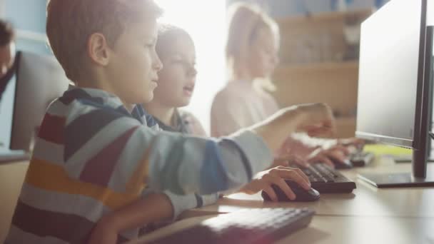 Scuola elementare aula di informatica: Ritratto di Smart Girl e Boy Talking durante l'utilizzo di Personal Computer, Imparare Informatica, Sicurezza Internet, Linguaggio di programmazione per la codifica del software — Video Stock