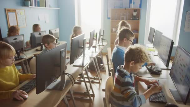 Класс информатики начальной школы: Разнообразная группа маленьких умных школьников, использующих персональные компьютеры, изучающих информатику, безопасность Интернета, язык программирования для программирования программного обеспечения — стоковое видео